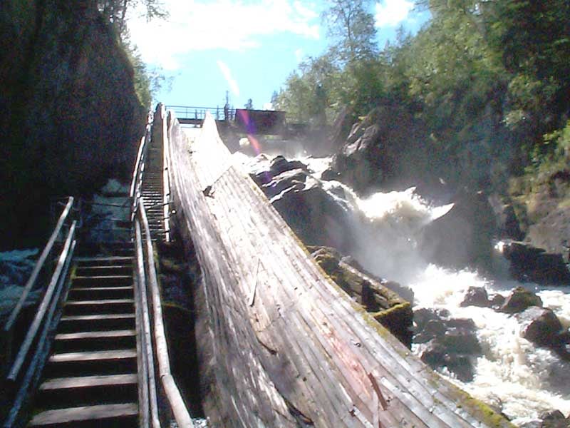 The Auttiköngäs waterfall with the wooden log flume and steps alongside