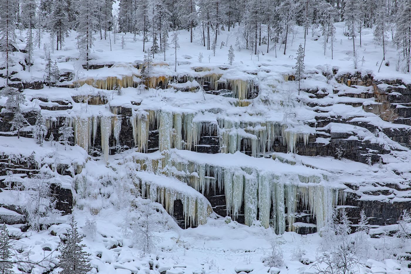 A wide curtain of icicles on a rock face in Korouoma canyon