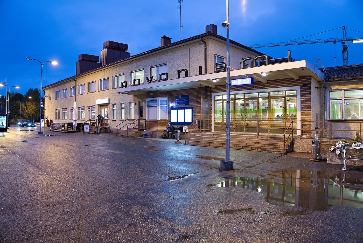 Rovaniemi railway station at dusk, with wet tarmac reflecting the station lights