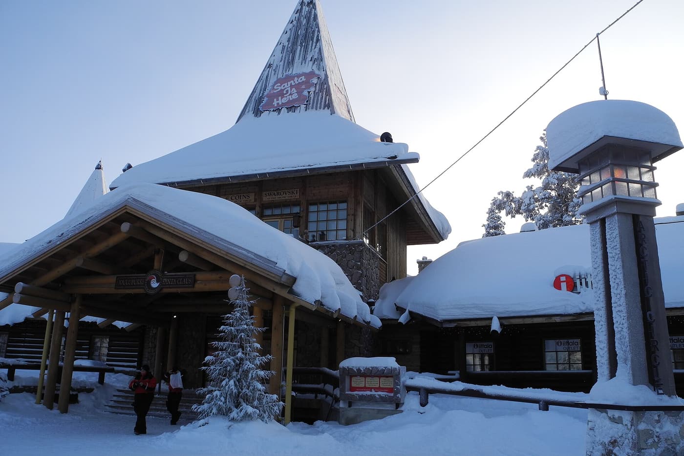 The snow-roofed main building of Santa Claus Village with its pointed tower