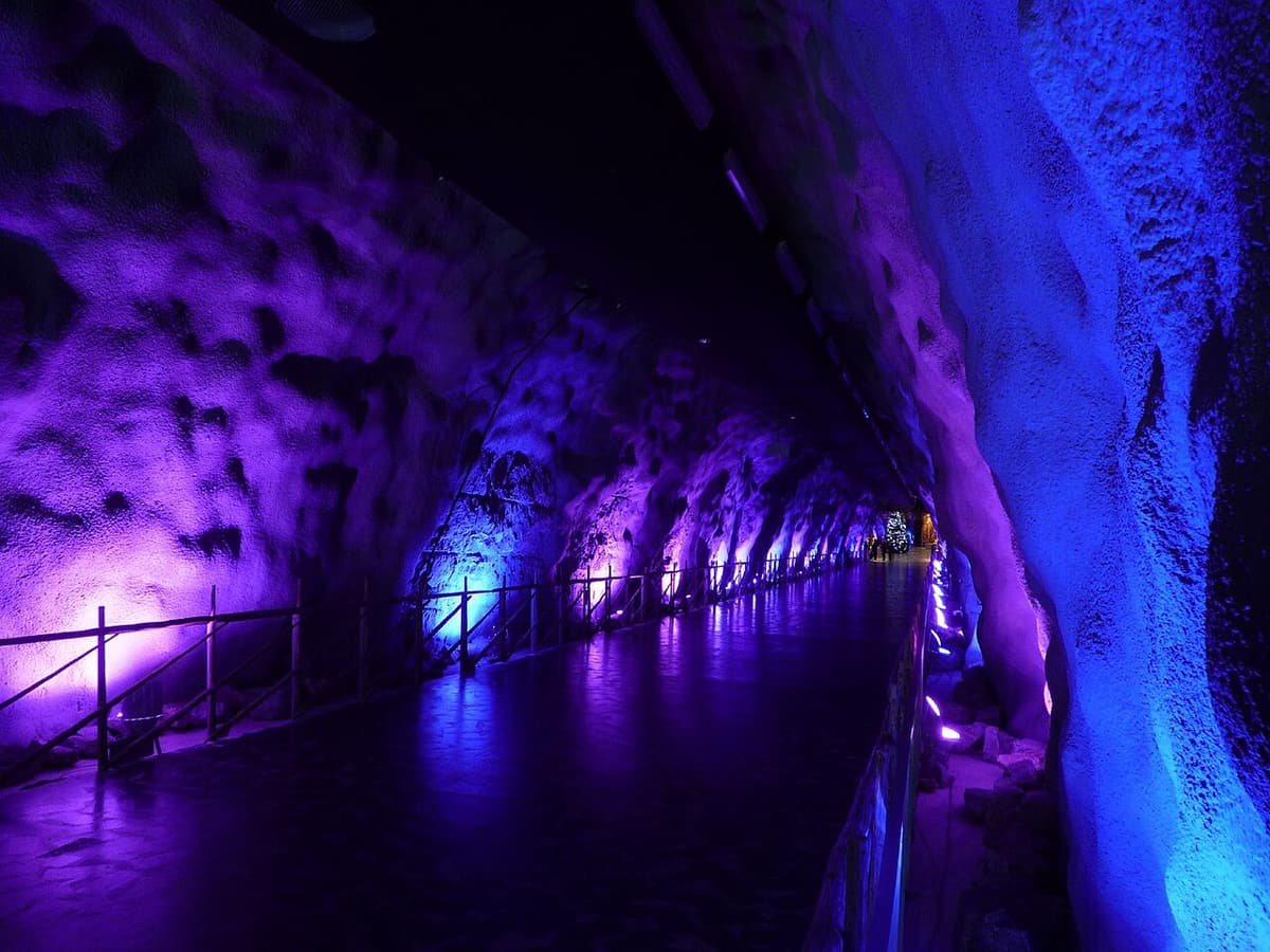 The purple-lit rock tunnel that leads down into the underground SantaPark