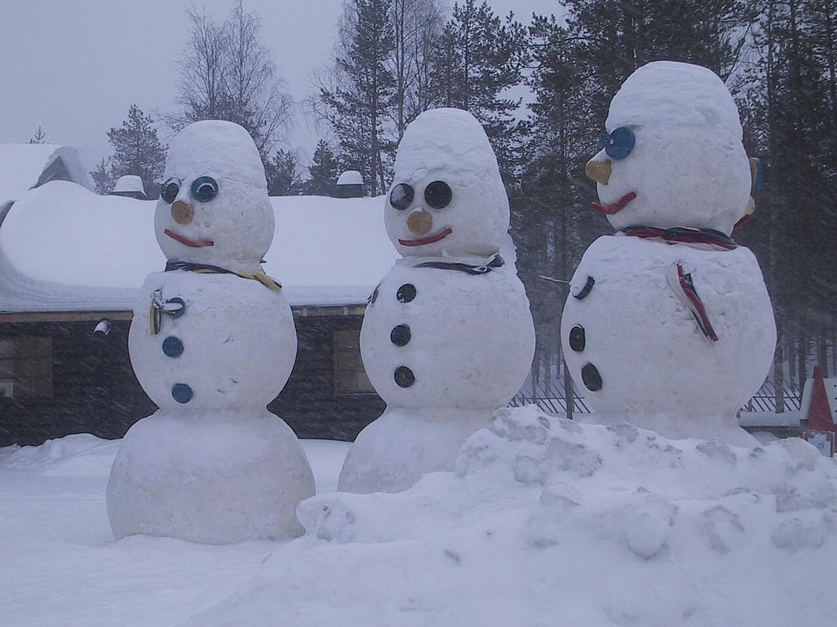 Three large snowmen wearing sunglasses in Santa Claus Village