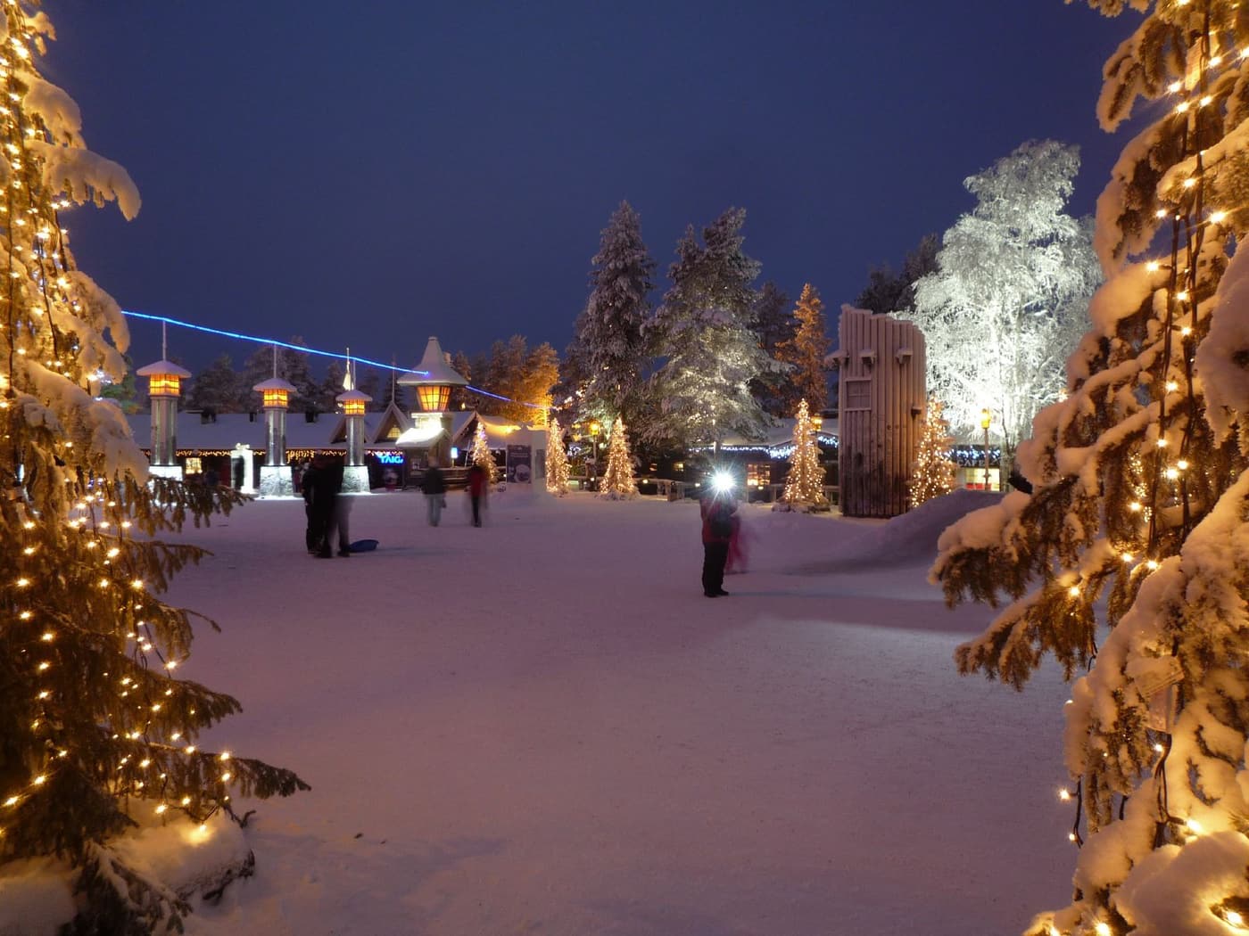 Santa Claus Village at blue hour with fairy lights on snow-laden trees